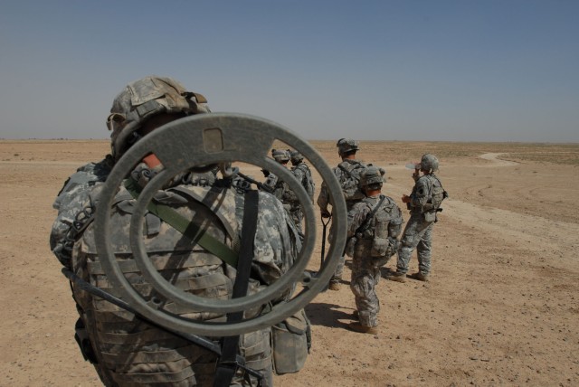 TAJI, Iraq - A metal detector operator prepares to move with fellow 56th Stryker Brigade Combat Team Soldiers to another search point in the desert near Nubai, June 3. Detectors, shovels and a little luck are some of the tools used to hunt for...