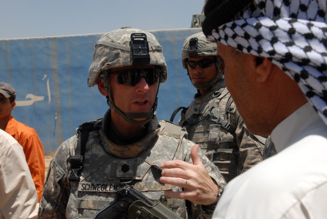 BAGHDAD - Lt. Col. Eric Schwegler, commander of the 1st Battalion, 82nd Field Artillery Regiment, 3rd Brigade Combat Team, 82nd Airborne Division, talks to Shaykh Qais Shater at the Tuwaitha Water Treatment Plant in Maid'in Quada, southeast of...