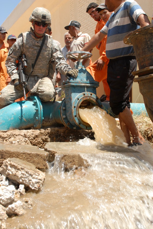 BAGHDAD - Sgt. James Brown of Binghampton, N.Y., a track vehicle mechanic assigned to Company G, 1st Battalion, 82nd Field Artillery Regiment, 3rd Brigade Combat Team, 82nd Airborne Division, observes river water flow from a valve he helped repair...