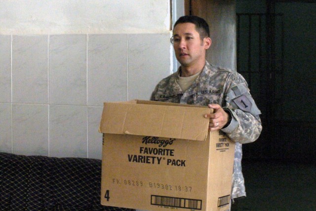 Cpt. Derek Kamachi, intelligence advisor to the Ninewa Police Transition Team, carries a box packed full of supplies out of their operations office at the Ninewa Iraqi Police Headquarters June 1. Coalition forces have begun the move towards exiting t...