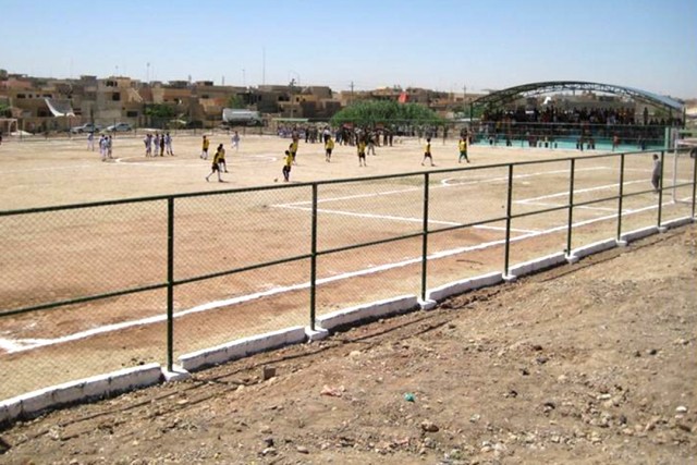 Iraqi children kick up a game of soccer on their new soccer field, which was completed and opened for use in the 7 Nissan neighborhood of Mosul May 30. Coalition forces coordinated with neighborhood locals to help fund and build the soccer field,...