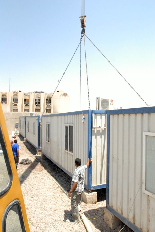 BAGHDAD- Iraqi contractors work on moving containerized housing units (CHU's) on Joint Security Station Basateen, June 2. In order to comply with the Security Agreement, the Soldiers of Company E,1st Battalion, 5th Cavalry Regiment, attached to the 1...