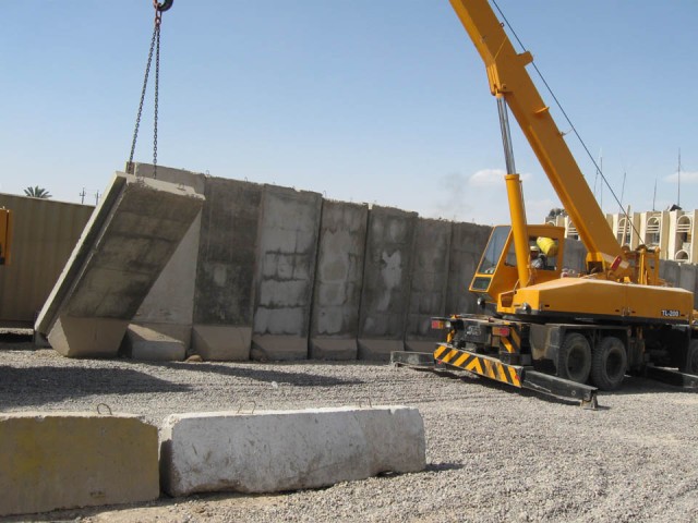BAGHDAD- An Iraqi contractor pulls down a concrete T-wall during the process of moving U.S. troops out of Joint Security Station Basateen, June 2. In order to comply with the Security Agreement, which states all U.S. combat troops will move out of th...