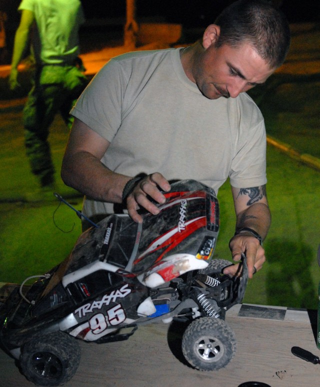 BAGHDAD - Pineville, La. native, Spc. Krider McCan of the 225th Engineer Brigade, does a pre-race check on his remote control car for the upcoming race held every Sunday on Camp Liberty, Iraq. For the past four years, armed service personnel have...