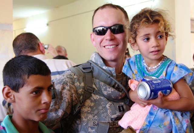 TAJI, Iraq - Capt. William Salisbury, of York, Pa., 328th Brigade Support Battalion, 56th Stryker Brigade Combat Team, Multi-National Division-Baghdad, meets two students from the school at the al-Boreyap, June 4. Salisbury and Soldiers of his...