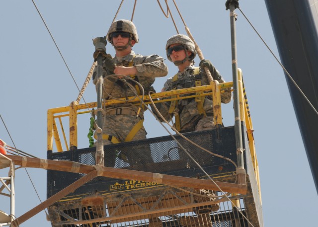 CAMP TAJI, Iraq - Spc. Kyle Adamski (left), of Duryea, Pa., and Spc. Shawna Teer, of Dallas, Pa., both with Headquarters and Headquarters Company, 56th Stryker Brigade Combat Team, perform maintenance to a radio antenna, June 4. The routine...