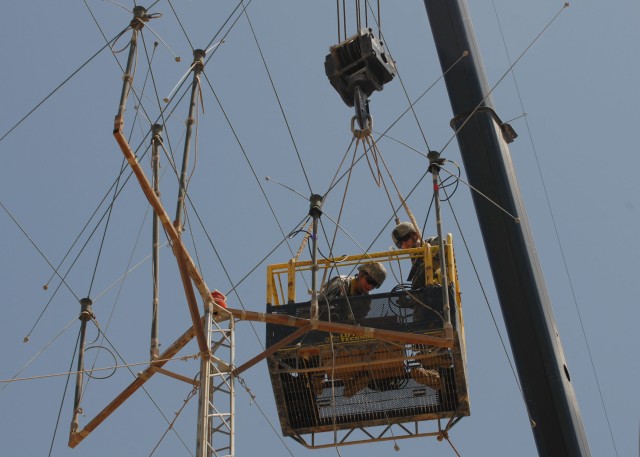 CAMP TAJI, Iraq - Spc. Shawna Teer, (left) of Dallas, Pa., and Spc. Kyle Adamski, of Duryea, Pa., both with Headquarters and Headquarters Company, 56th Stryker Brigade Combat Team, perform maintenance to a radio antenna, June 4. The routine...