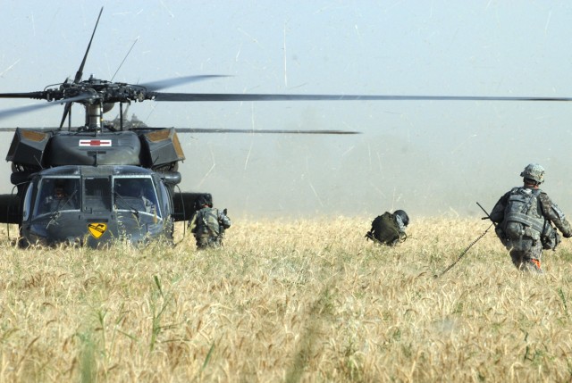 BAGHDAD - Crewmembers of 1st Air Cavalry Brigade prepare UH-60 Blackhawk helicopters to airlift injured Soldiers from the wheat field in the Abu Ghraib area, June 3.  The crewmembers want to ensure the Soldiers carrying the litters do not get near th...