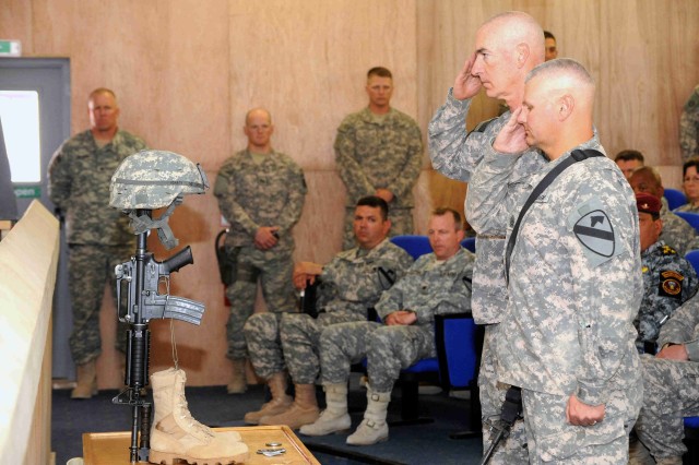 BAGHDAD - Maj. Gen. Daniel Bolger (left), commander of Multi-National Division-Baghdad, and Command Sgt. Maj. Rory Malloy, senior enlisted leader of the MND-B, pay their respects to Sgt. Justin Duffy during a memorial ceremony, June 7, at Joint...