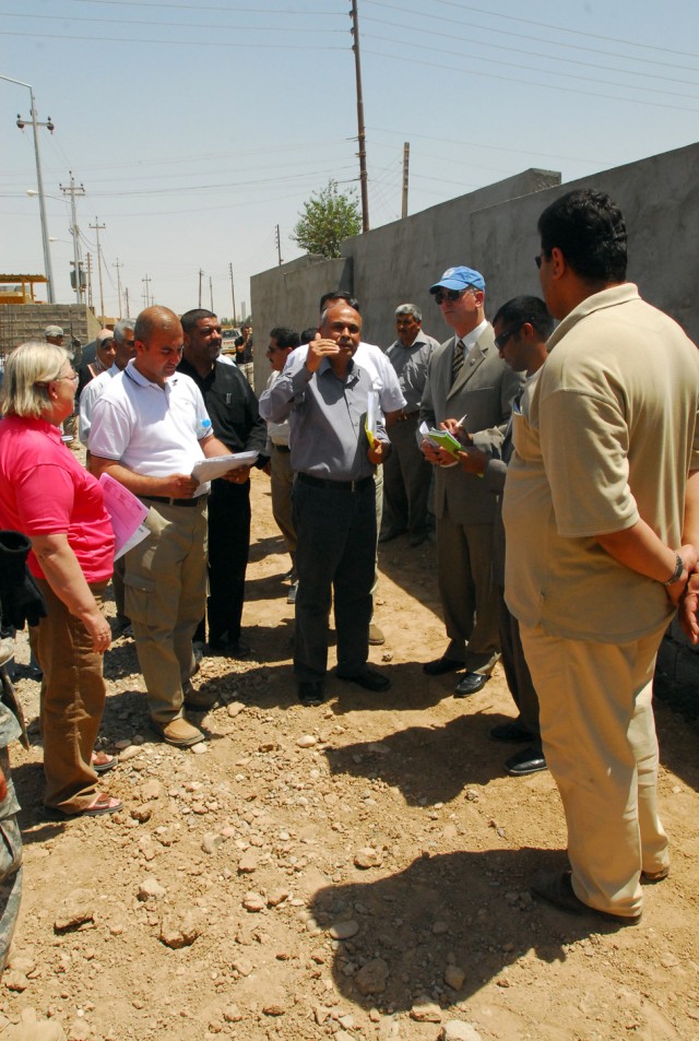 Tim Moore (wearing hat) of the U.S. Agency for International Development meets with the community action group in Laylan, Iraq, June 4, during a visit to the Laylan Roman Primary School to verify new construction efforts in a combined project...