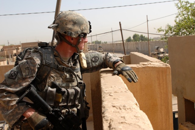 BAGHDAD - Spc. Justin Davis, an infantryman from Walkertown, N.C., assigned to Company A, 252nd Combined Arms Battalion, 30th Heavy Brigade Combat Team, scans an alleyway from a rooftop during a joint abandoned building search in Doura, here, June...