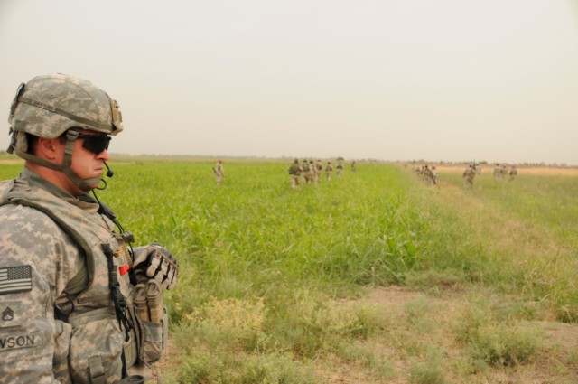 BAGHDAD - Staff Sgt. Brian Dawson of Winston Salem, N.C., brings up the rear of an Iraqi Army led patrol, south of Baghdad, June 9. Dawson, a section chief with Battery B, 113th Field Artillery Regiment, 30th Heavy Brigade Combat Team, and a small...