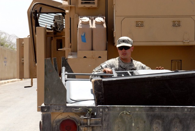 BAGHDAD - Spc. Jordan Sullivan, a native of Petluma, Calif., and a cavalry scout assigned to C Troop, 5th Squadron, 4th Cavalry Regiment, 2nd Brigade Combat Team, 1st Infantry Division loads his trailer after the transfer of authority ceremony at...