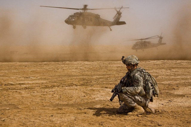 TAJI, Iraq - Sgt. Ryan Crook, from Orange Park, Fla., a team leader in Company F, 3rd Battalion, 1st Air Cavalry Brigade, 1st Cavalry Division, Multi-National Division - Baghdad, pulls security as two UH-60 Black Hawk helicopters depart the training ...