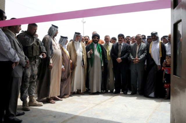 BAGHDAD - Community leaders from the city of Shawa Wa Um Jidir, located in the 9 Nissan district of eastern Baghdad, gather in front of the new civil support district center building during the opening ceremony of the facility June 11. The center...