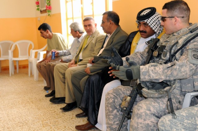 BAGHDAD - Capt. Patrick Flynn, of Raeford, N.C., speaks with key leaders of the city of Shawa Wa Um Jidir, located in the 9 Nissan District of eastern Baghdad during the opening of the civil support district center building. The center will offer...