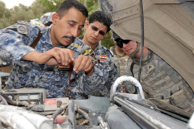 BAGHDAD - Capt. Moaed Qasin Mohammed (left), a company commander and his driver, Sgt. Saefe Fadhel Nassir (center), both assigned to 1st Company, 3rd Battalion, 7th Brigade, 2nd National Police Division, take a look under the hood of a humvee as...
