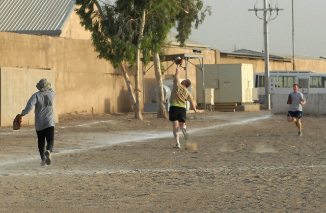 BAGHDAD - Staff Sgt. Jeremy Amis (center) runs down a fly ball in left field from his short stop position during the championship game of a Morale Welfare and Recreation center sponsored softball tournament on June 11 at Camp Victory, Iraq. Amis,...