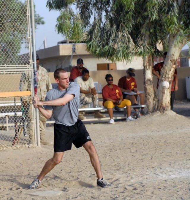 BAGHDAD - Sgt. Daniel Ehardt, an operations sergeant serving with Headquarters and Headquarters Company, 56th Infantry Brigade Combat Team, keeps his eyes on the ball as he prepares to swing away during the championship game of a Morale Welfare and R...