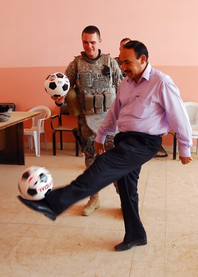 BAGHDAD - Director Hansen, of the Abu Ghraib Youth Center, dribbles one of the 50 soccer balls presented as a gift by Capt. Jason Hoffman, from York, Pa., with Company B, 2nd Battalion, 112th Infantry Regiment "Paxton Rangers," 2nd Heavy Brigade...