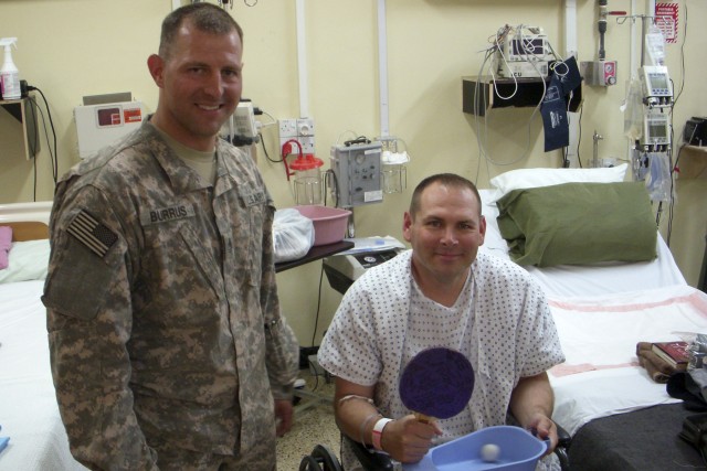 First Sergeant Brian Allen poses with Sgt. 1st Class Billy Burruss, platoon sergeant for 1st Platoon, B. Troop, 4th Sqdn., 9th Cav. Regt., after receiving a ping-pong ball and paddle as a recovery gift during his stay at the Forward Operating Base...