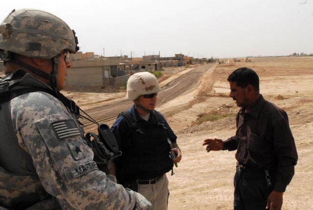 Sgt. Carlos Martinez (left), Ventura, Calif. native with the 490th Civil Affairs Battalion, and Abbas Ali (center), from Vancouver, Canada and a civil engineer with the Provincial Reconstruction Team in Kirkuk, Iraq, talk with a local Iraqi contracto...