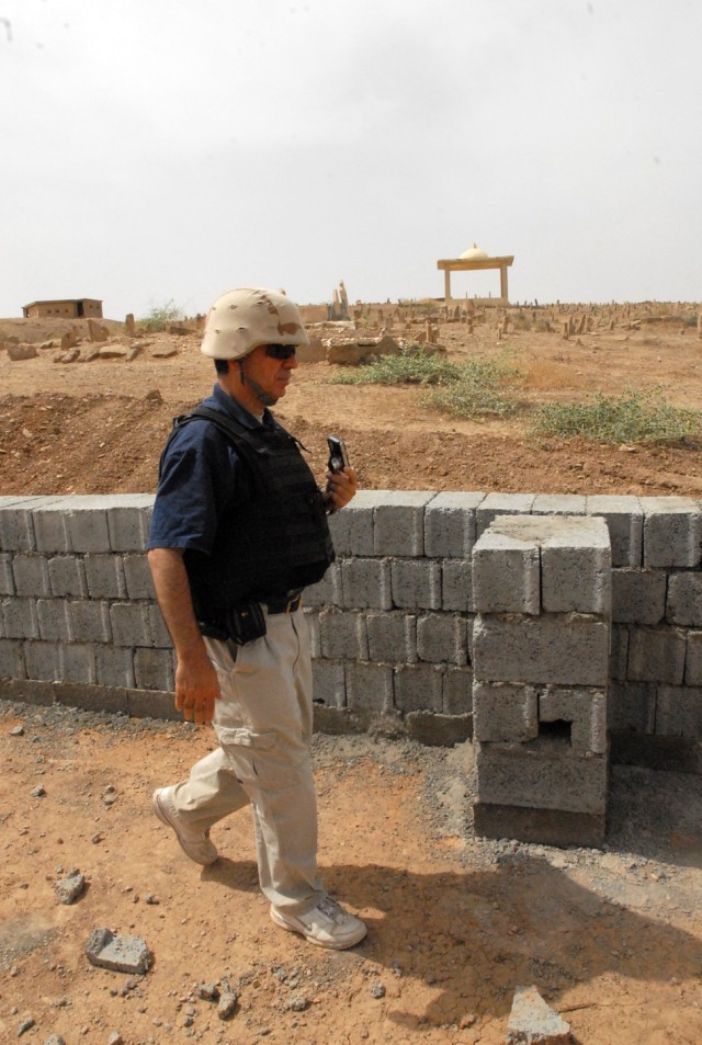Abbas Ali, from Vancouver, Canada and a civil engineer with the Provincial Reconstruction Team in Kirkuk, Iraq, checks the construction status of a retaining wall to protect a cemetery from a construction project to build roads connecting facilities ...