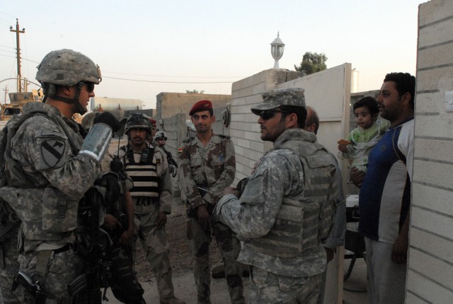 Soldiers from 1st Battalion, 8th Cavalry Regiment, 2nd Brigade Combat Team, 1st Cavalry Division, and Iraqi soldiers from the 1st Battalion, 47th Iraqi Brigade conduct a "meet and greet" during a combined patrol through the streets of Gumbaltar...