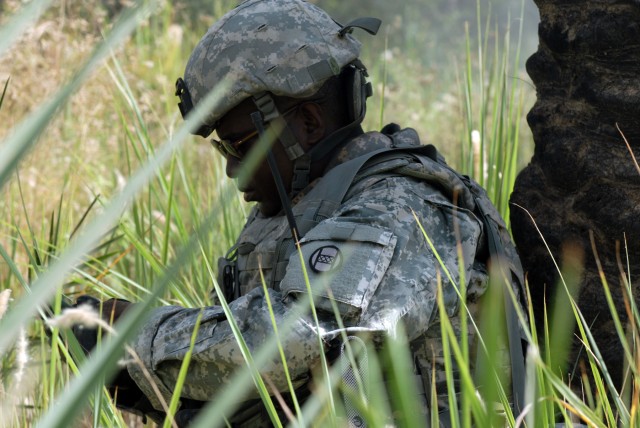 BAGHDAD - Sgt. Vincent Bell of Charlotte, N.C., checks a radio during a sweep of a palm grove near Doura, here, June 13. Bell, an infantryman assigned to the North Carolina National Guard's Company A, 252nd Combined Arms Battalion, 30th Heavy...