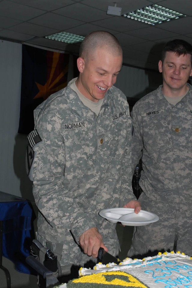 BAGHDAD - Boulder, Colo. native Maj. Geoffrey Norman (left), executive officer for the 1st "Ironhorse" Brigade Combat Team, 1st Cavalry Division festively cuts himself a piece of the Army's 234th Birthday Cake following the traditional ceremony the b...