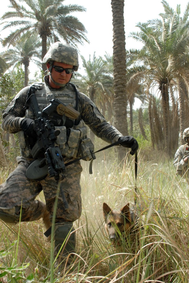 BAGHDAD - Nero, a German Sheppard military working dog, and his handler, Castle Dale, Utah native, Air Force Staff Sgt. Christopher Ebeling, a military working dog handler assigned to Camp Victory Provost Marshall's Office, lead a group of Soldiers f...