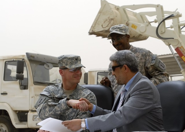 BAGHDAD -Col. Joseph Martin, a native of Dearborn Mich., commander, 2nd Heavy Brigade Combat Team, 1st Infantry Division, Multi-National Division - Baghdad, shakes the hand of Naeem Abaob, the deputy mayor of Baghdad, after they signed the...