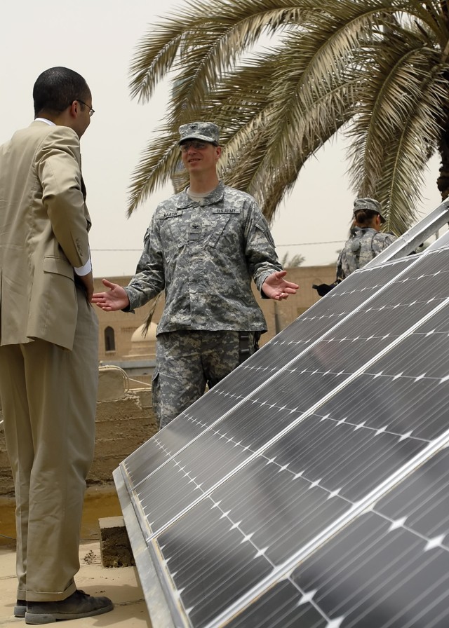 BAGHDAD - Col. Joseph Martin, a native of Dearborn, Mich., commander, 2nd Heavy Brigade Combat Team, 1st Infantry Division, Multi-National Division - Baghdad, speaks with Mark Powell, team leader of the 2nd HBCT's embedded Provisional...