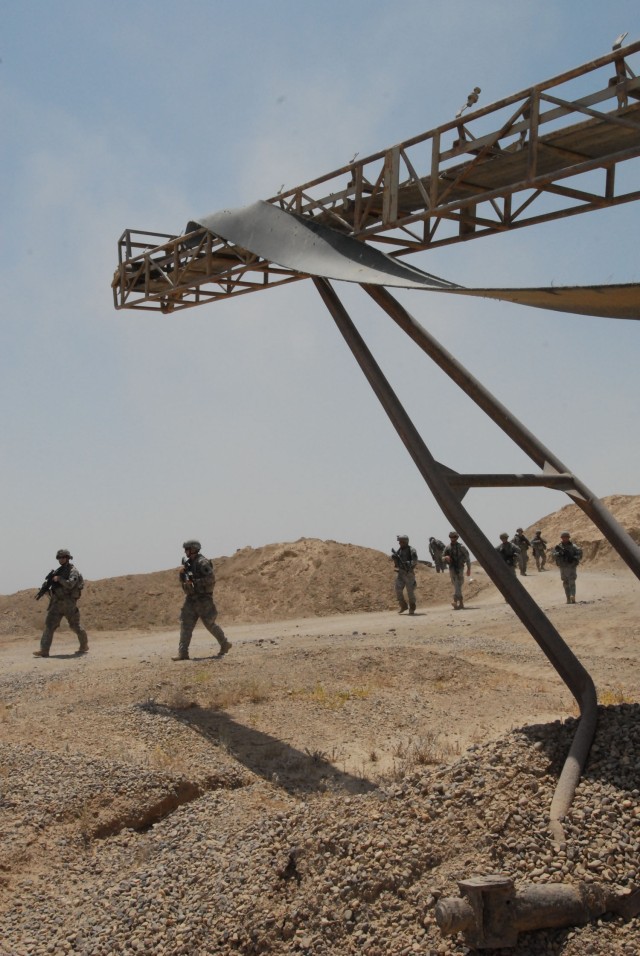 NUBAI, Iraq - Soldiers from Headquarters and Headquarters Company, 1st Battalion, 111th Infantry Regiment, and 856th Engineer Company, 56th Stryker Brigade Combat Team, enter a quarry near Nubai, north of Baghdad, June 16 during a search for...