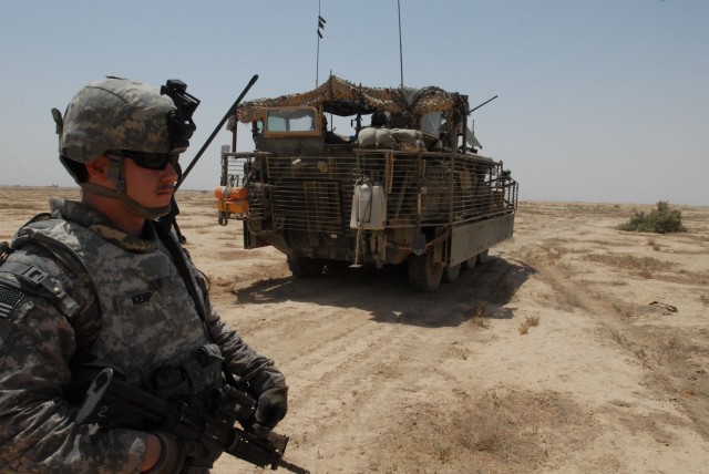NUBAI, Iraq - Spc. Jake Kemp of Phoenix, Ariz., with Headquarters and Headquarters Company, 1st Battalion, 111th Infantry Regiment, pulls security in the desert near Nubai, north of Baghdad, during a search for weapons caches June 16. Kemp joined...