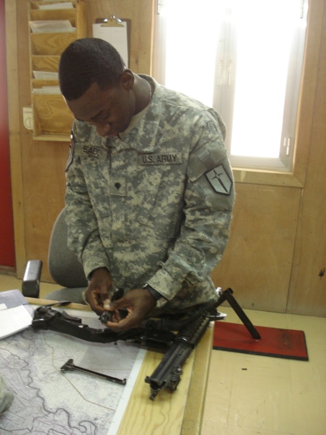 BAGHDAD - As a unit armorer Spc. Aljalel Eaddy, who hails from Gresham, S.C.,  inspects an M-4 rifle for cleanliness and serviceability.  Eaddy also serves as a unit supply specialist for Company A, 46th Engineer Combat Battalion (Heavy) with the...