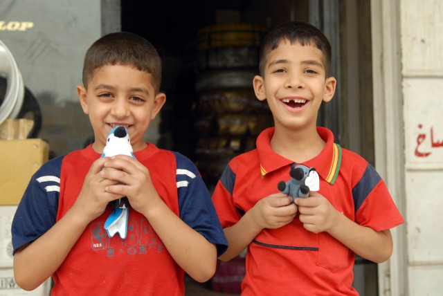 BAGHDAD - Two Iraqi boys smile after receiving stuffed animals from Iraqi Police in the Ameriyah neighborhood during a joint patrol with the IP and Soldiers of the 463rd Military Police Company, 93rd Military Police Battalion, 8th Military Police...