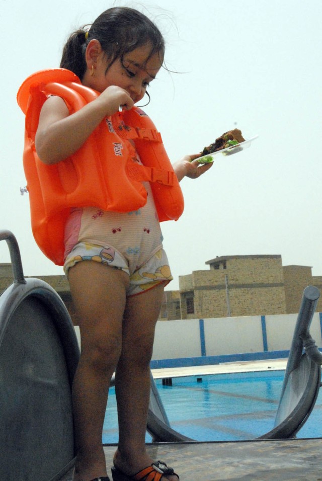 BAGHDAD, Iraq - A young girl stands at the top of a slide that leads into the children pool after the grand opening ceremony of the Sha'ab pool on June 17. "The pool is designed to provide the families of Sha'ab a safe place for summertime...