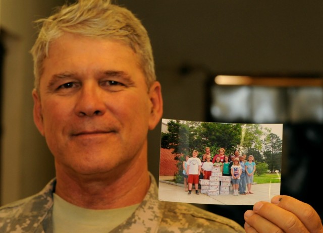 BAGHDAD -Staff Sgt. Dale O'Neill, from Memphis, Tenn., holds a picture, June 17, of the group of students who helped collect items for care packages. The children, who attend school with O'Neill's 6-year-old daughter, collected more than 120...