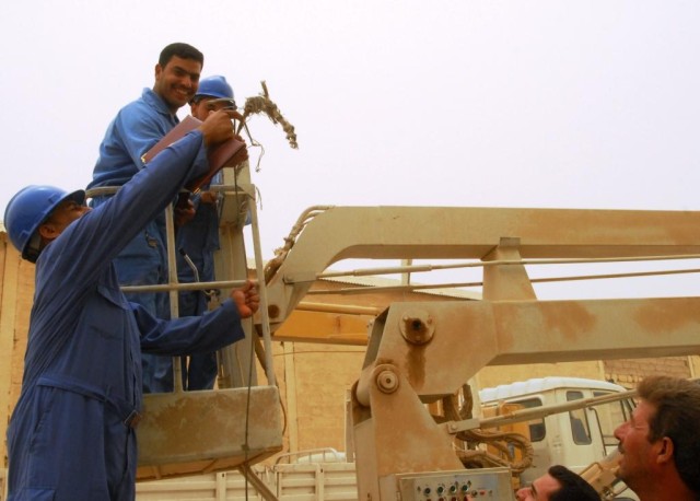 CAMP TAJI, Iraq - Students of the Electrical Line Refurbishment Team course in Tarmiyah demonstrate their new repair skills in a U.S.-funded bucket truck. Twenty students graduated the six-week class which gave them skills needed to work on...