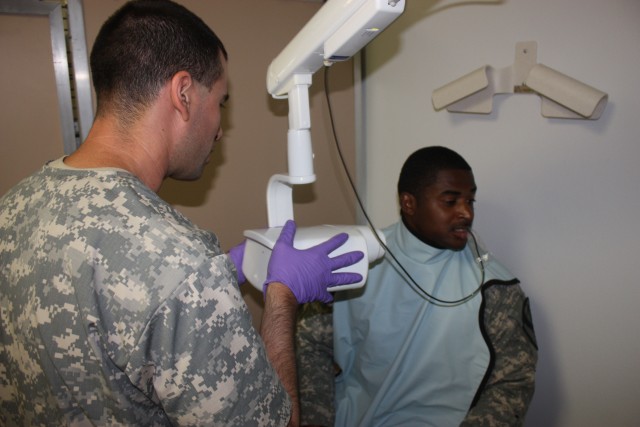Capt. Shahnaaz Nistar, a dentist who works at the Reverse Soldier Readiness Processing site, examines Staff Sgt. Jonathen Engram, a native of Jacksonville, Fla., assigned to the 5th Battalion, 82nd Field Artillery Regiment, 4th Brigade Combat...