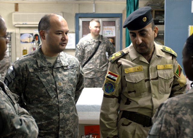 BAGHDAD - Maj. Joseph Novack (left), senior physician, 299th Brigade Support Battalion, 2nd Heavy Brigade Combat Team, 1st Infantry Division, speaks with Lt. Col. Mortadha Jafar Mosa, 6th Iraqi Army Division surgeon, during a tour of the Riva...