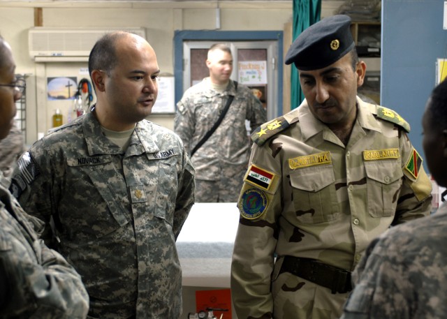 BAGHDAD - Maj. Joseph Novack (left), senior physician, 299th Brigade Support Battalion, 2nd Heavy Brigade Combat Team, 1st Infantry Division, speaks with Lt. Col. Mortadha Jafar Mosa, 6th Iraqi Army Division surgeon, during a tour of the Riva Ridge T...