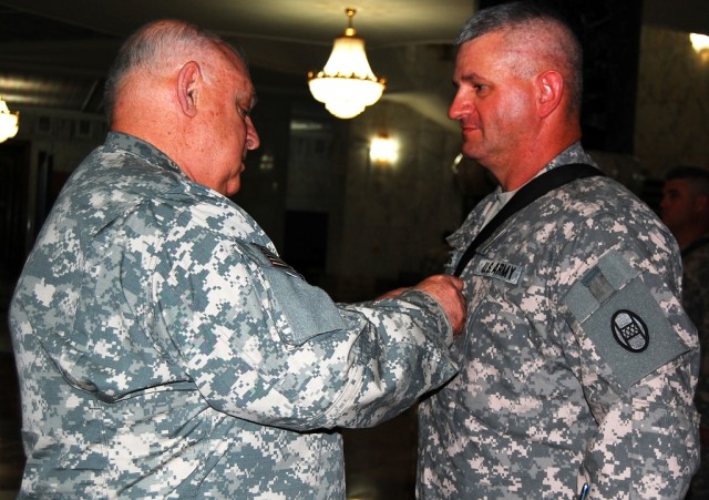 BAGHDAD- Maj. Gen. Allen Tackett (left), the West Virginia National Guard State Adjutant General, promotes 1st Sgt. Don Fleming after a reenlistment ceremony at Camp Victory Base Complex, June17.   Tackett re-capped the accomplishments of...