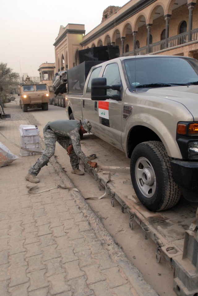 BAGHDAD- Detroit, Mich. native, Spc. Carlos Smith, a driver for A Company, 115th Brigade Support Battalion, 1st Brigade Combat Team, 1st Cavalry Division works to unload one of the five Ford F-350s for the 11th Iraqi Army Division, June 19. The...