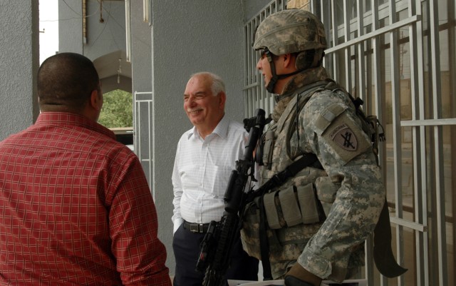 Master Sgt. Felipe Azua, of Plainview, Texas, a team chief with Company B, 410th Civil Affairs, speaks with Kirkuk Chamber of Commerce director Sabah Alden Mohammed Salih al Salhi (center) and a member of Citadel, a communications company about a bus...