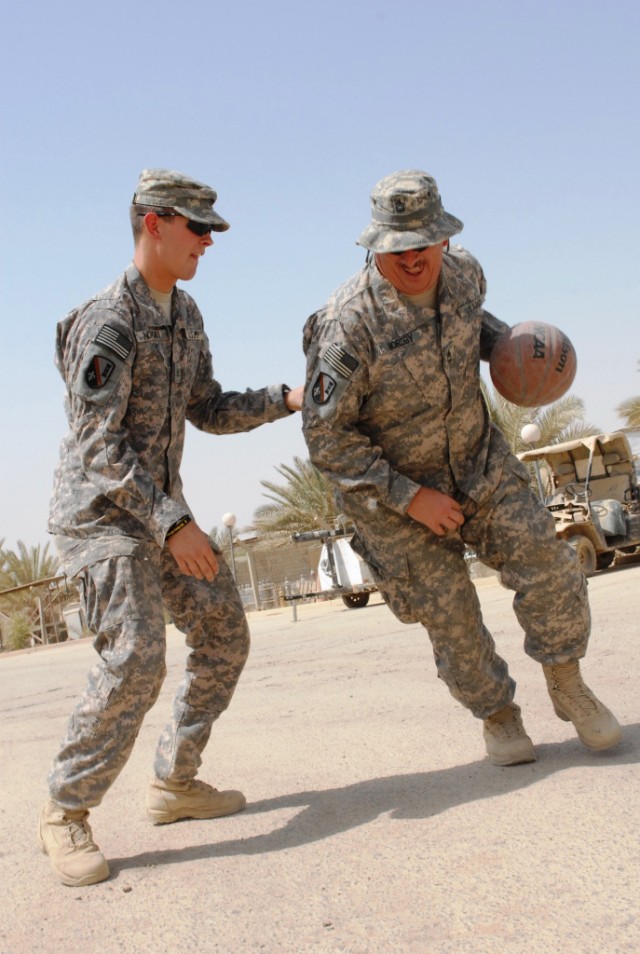BAGHDAD - Pineville, La., natives Sgt. 1st Class Rodney Nordby (right) tries to score on his, Curtis (left), June 22. The father-son duo from the 225th Engineer Brigade said having each other has made their deployment to Baghdad much easier. In...