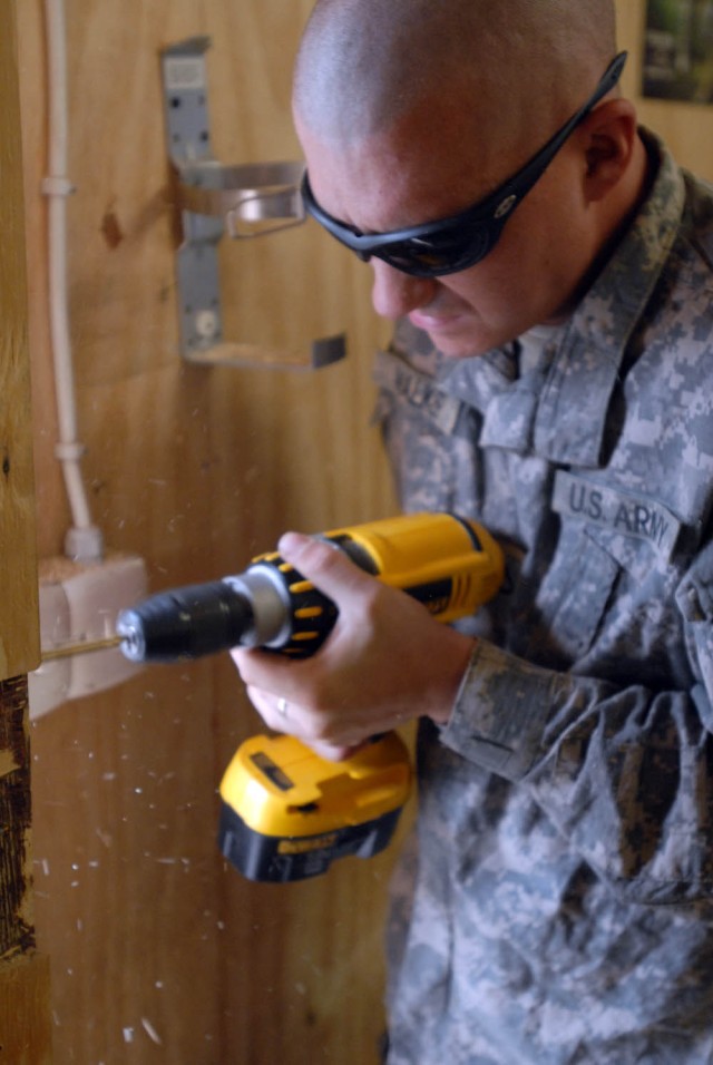 BAGHDAD -Kokomo, Ind. native, Pfc. Nathan Walker, a tanker for C Company, 2nd "Lancer" Battalion, 5th Cavalry Regiment,  1st "Ironhorse" Brigade Combat Team, 1st Cavalry Division, works on the door to the new Morale, Welfare and Recreation building, ...