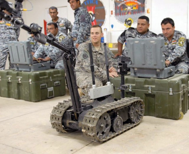 BAGHDAD - Staff Sgt. Joseph Ray (center), of Baton Rouge, La., watches as his students, 2nd National Police officers, operate the Talon robot, June 24. The class was part of a three-day course on route clearance taught at the 225th Engineer...