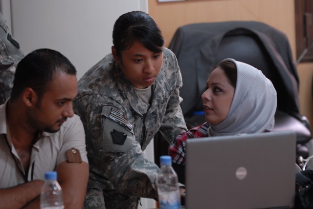 Pfc. Amanda Po, a geospatial analyst with Headquarters Company, 56th Stryker Brigade Combat Team, shows Iraqi Ministry of Water and Ministry of Agriculture technicians features of a mapping program, June 21, during a conference in the...